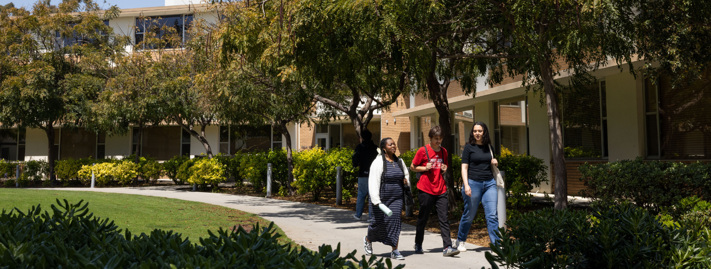 Three students walk in the first-year quad on LMU's campus